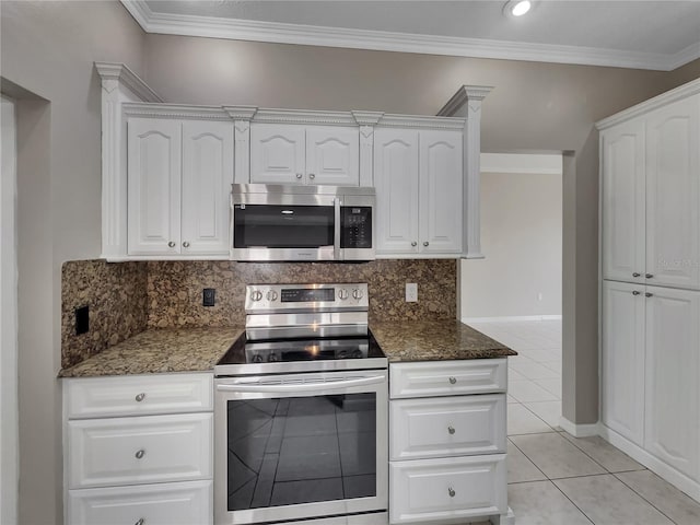 kitchen featuring dark stone counters, tasteful backsplash, light tile patterned floors, stainless steel appliances, and white cabinets