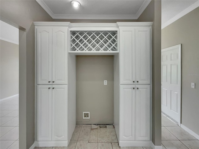 laundry area with light tile patterned floors, baseboards, and crown molding