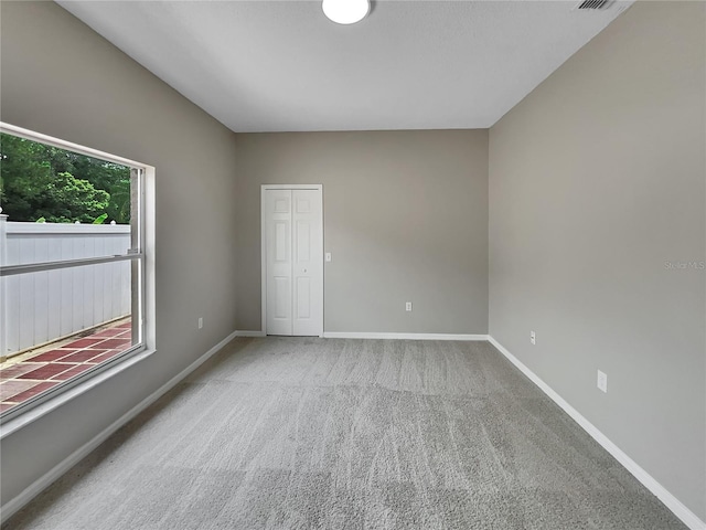 spare room with carpet and baseboards