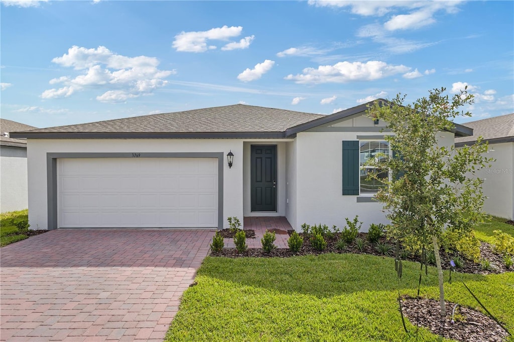 ranch-style home with a front yard and a garage