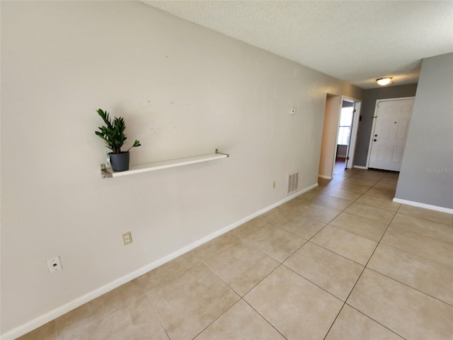 tiled spare room with a textured ceiling