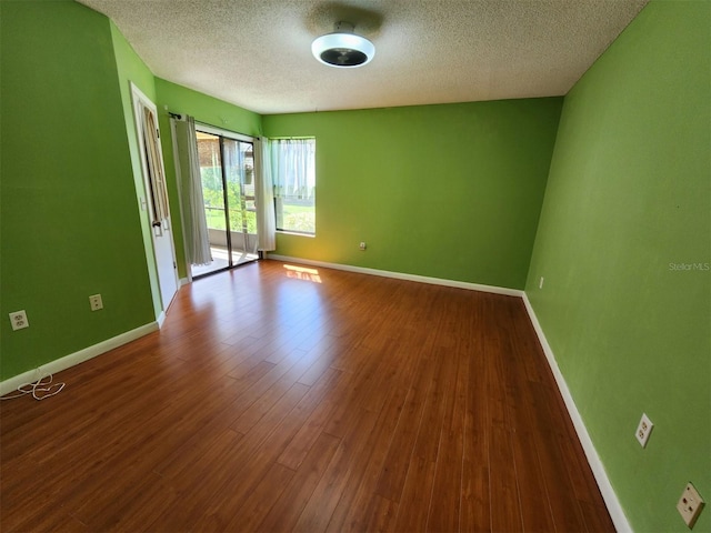 spare room featuring a textured ceiling and hardwood / wood-style flooring