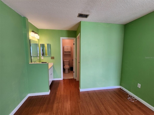 empty room with a textured ceiling and hardwood / wood-style flooring