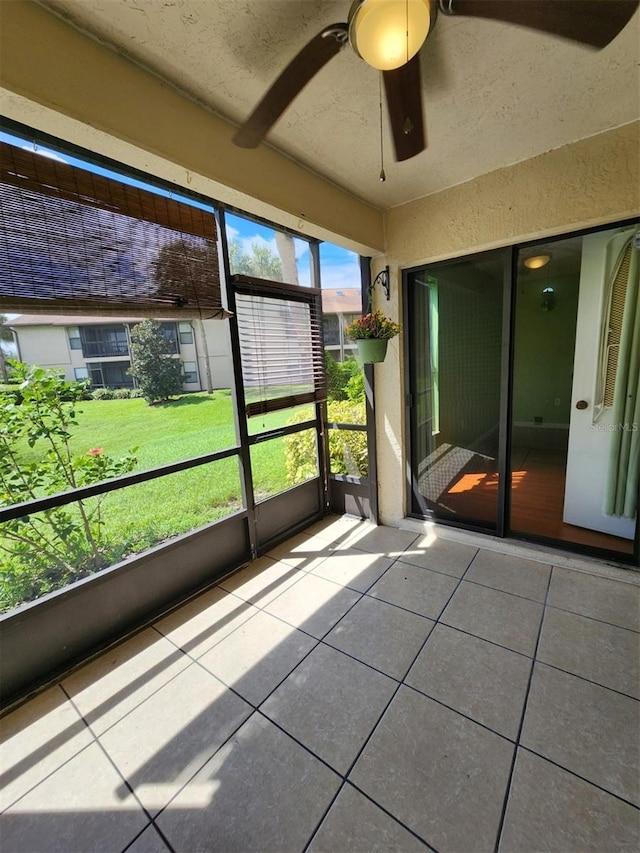 unfurnished sunroom featuring ceiling fan