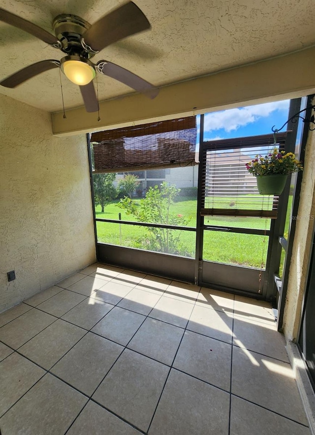 unfurnished sunroom featuring a wealth of natural light and ceiling fan