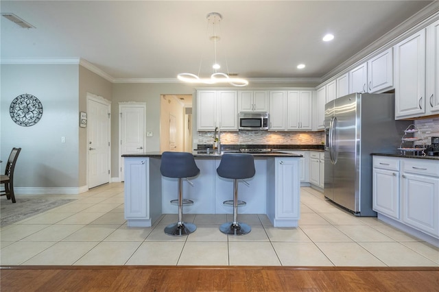 kitchen featuring stainless steel appliances, white cabinets, a center island with sink, and a kitchen breakfast bar