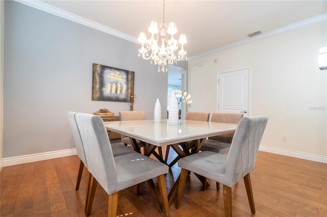 dining space with crown molding and light hardwood / wood-style floors