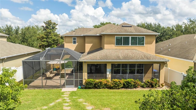 back of house featuring a patio, a yard, and a lanai