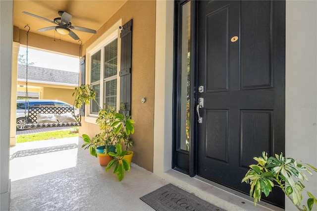 doorway to property with a porch and ceiling fan