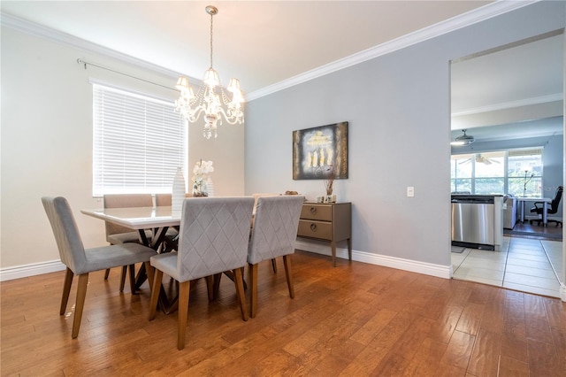 dining space with hardwood / wood-style flooring, ceiling fan with notable chandelier, and ornamental molding