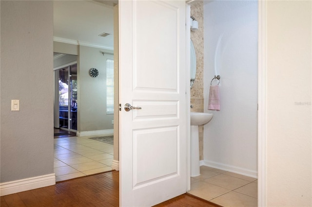 bathroom with wood-type flooring and crown molding