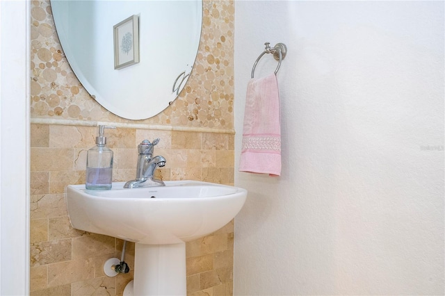 bathroom featuring sink and tile walls