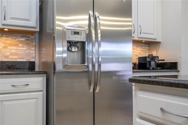 kitchen featuring decorative backsplash, dark stone countertops, stainless steel fridge with ice dispenser, and white cabinetry