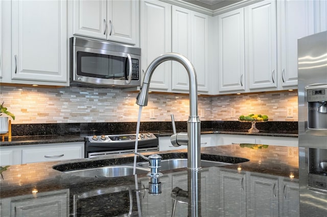 kitchen with tasteful backsplash, appliances with stainless steel finishes, and white cabinetry