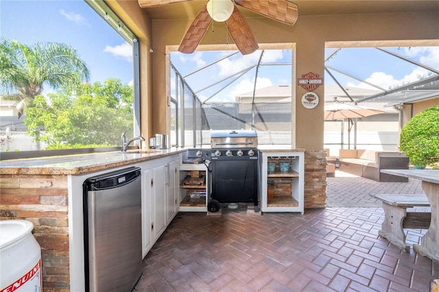 view of patio / terrace with ceiling fan, glass enclosure, sink, and exterior kitchen