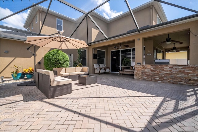 view of patio / terrace featuring an outdoor living space, glass enclosure, and ceiling fan