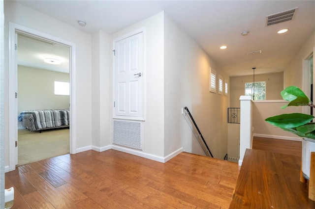 hall with a notable chandelier and hardwood / wood-style floors