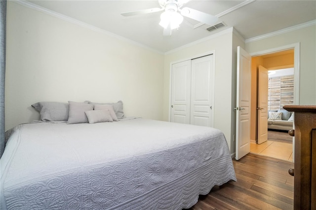 bedroom with wood-type flooring, a closet, crown molding, and ceiling fan