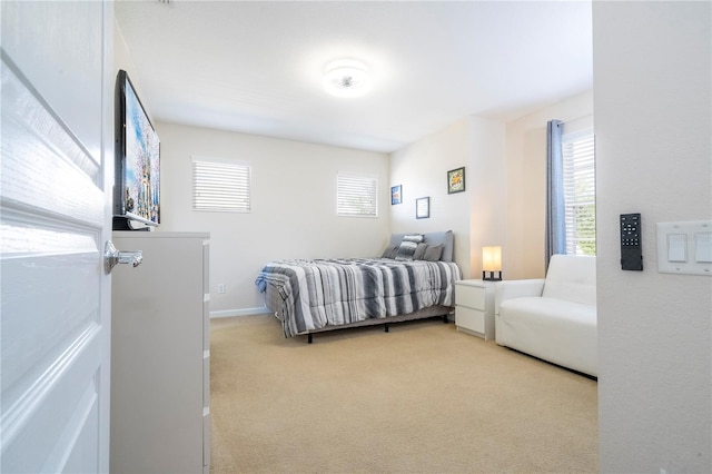 bedroom featuring light colored carpet and multiple windows