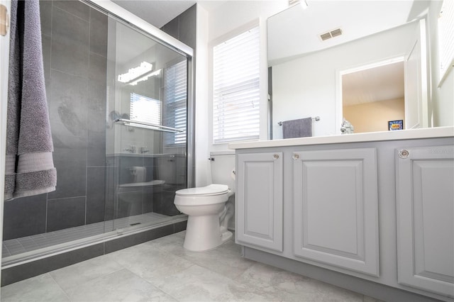 bathroom featuring a shower with shower door, vanity, and toilet