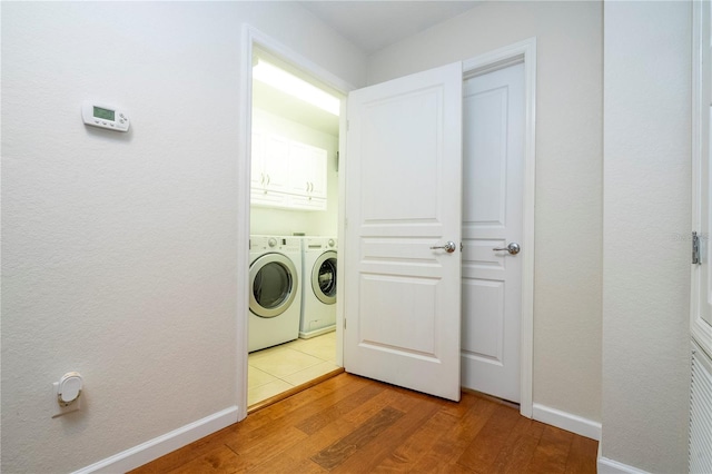 clothes washing area featuring washer and clothes dryer and light hardwood / wood-style floors