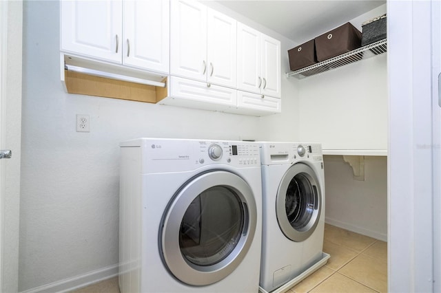 clothes washing area with cabinets, light tile patterned flooring, and independent washer and dryer