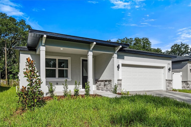 view of front of home featuring a porch, a garage, and a front lawn