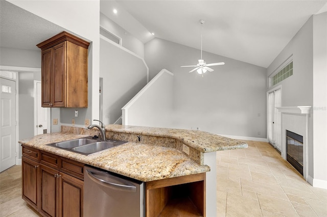 kitchen featuring light stone counters, sink, ceiling fan, vaulted ceiling, and stainless steel dishwasher