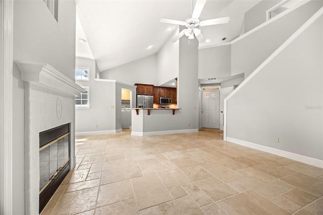 unfurnished living room featuring ceiling fan and high vaulted ceiling