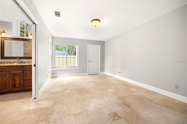 interior space featuring sink and a textured ceiling