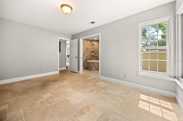 interior space featuring a textured ceiling and ensuite bath