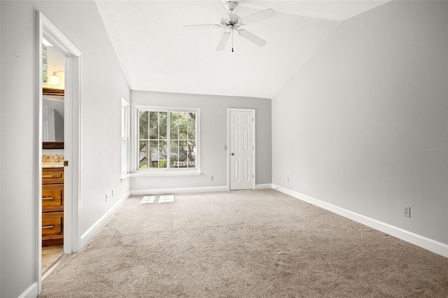 interior space with ceiling fan, carpet floors, and vaulted ceiling