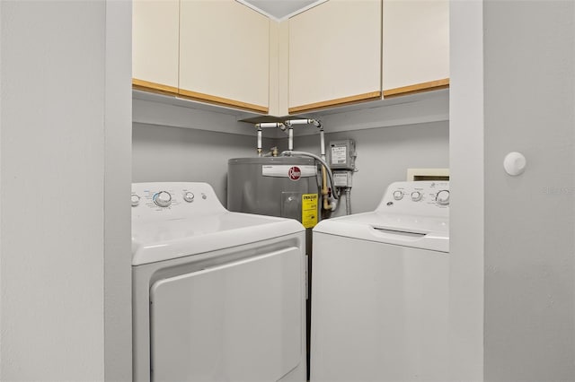 laundry area with cabinets, washer and clothes dryer, and water heater