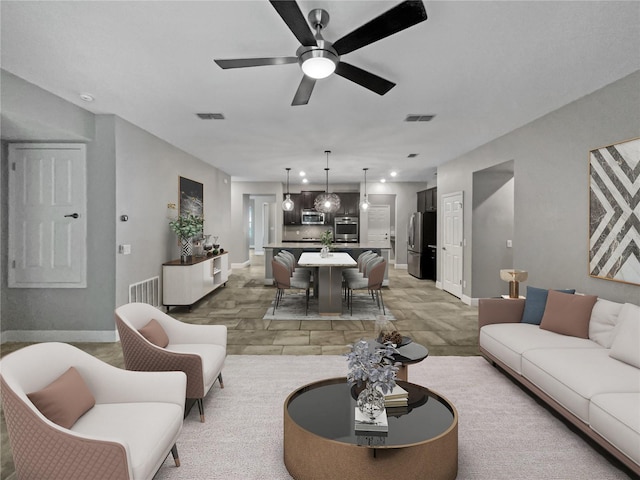 living room with light hardwood / wood-style flooring and ceiling fan