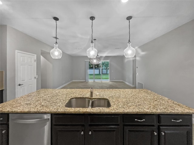 kitchen featuring a center island with sink, stainless steel dishwasher, sink, and decorative light fixtures