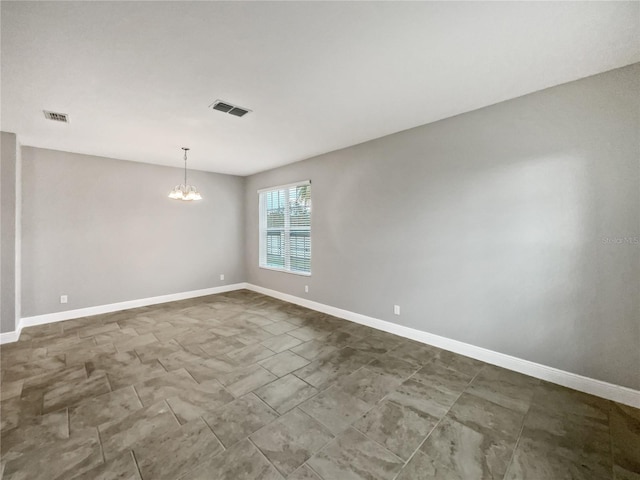 spare room with an inviting chandelier