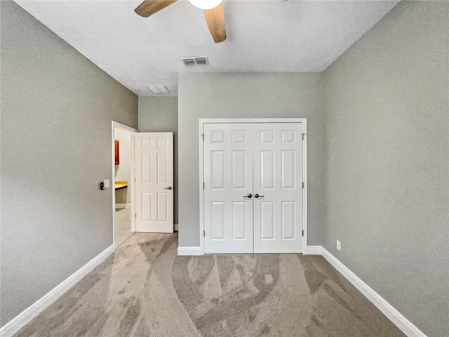 unfurnished bedroom with light colored carpet, ceiling fan, and a closet