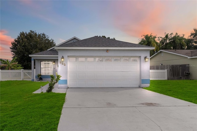 ranch-style house featuring a garage and a lawn