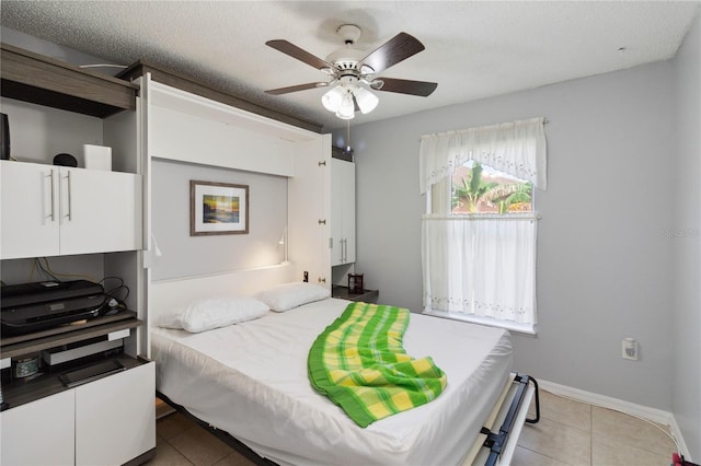 bedroom featuring a textured ceiling, tile patterned floors, and ceiling fan