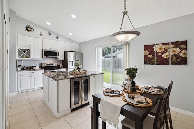 kitchen featuring pendant lighting, white cabinetry, wine cooler, stainless steel appliances, and a center island with sink