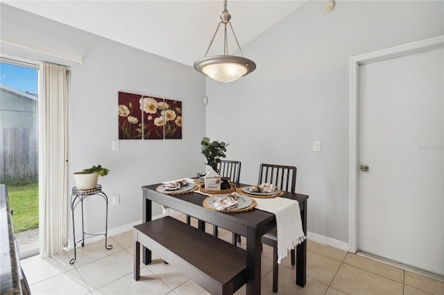 dining room featuring lofted ceiling and light tile patterned flooring