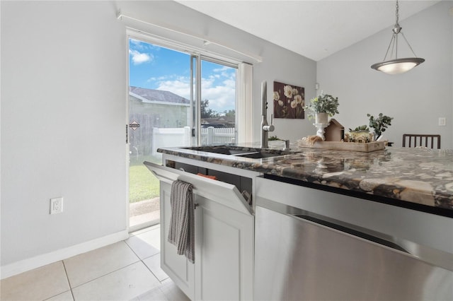 kitchen with sink, white cabinetry, light tile patterned floors, stainless steel dishwasher, and pendant lighting