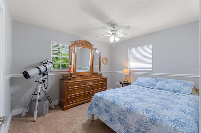 bedroom featuring ceiling fan, light colored carpet, and baseboards