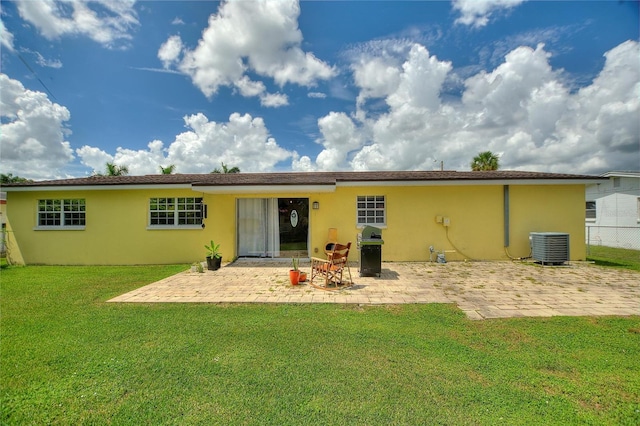 rear view of property featuring a lawn, fence, a patio area, and stucco siding