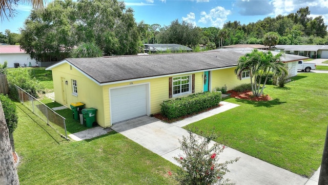 ranch-style house with fence, a shingled roof, a garage, a front yard, and driveway
