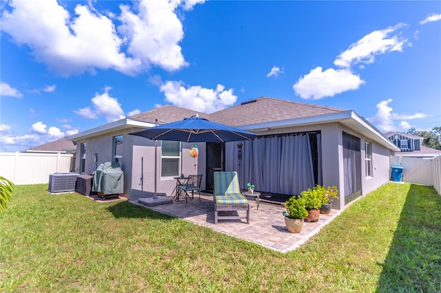 back of property featuring a lawn, a patio area, and central air condition unit