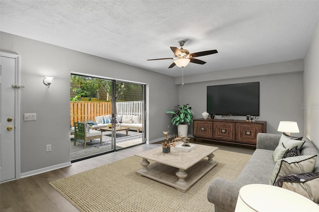 living room with ceiling fan, a textured ceiling, and wood-type flooring