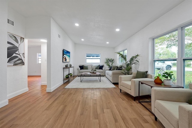 living room featuring lofted ceiling and light hardwood / wood-style flooring