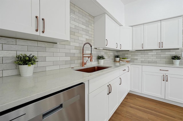 kitchen with white cabinetry, light hardwood / wood-style flooring, and stainless steel dishwasher