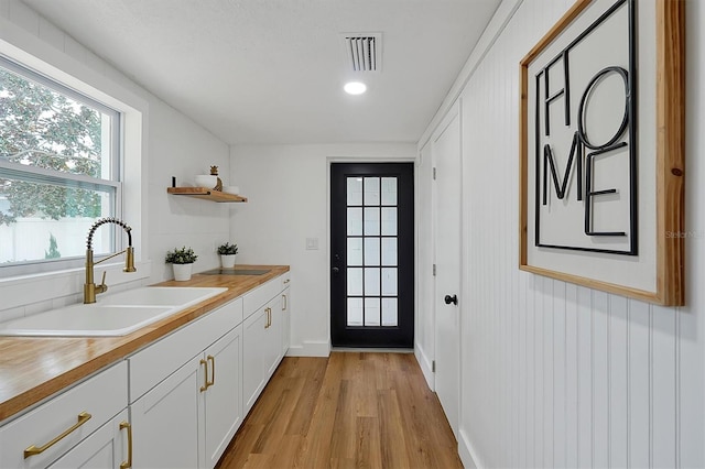 kitchen featuring light hardwood / wood-style flooring, white cabinetry, and sink